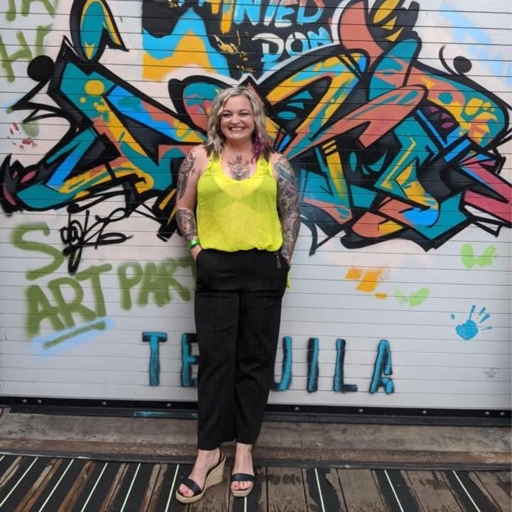 Selena Humphrey standing against a colorful wall
