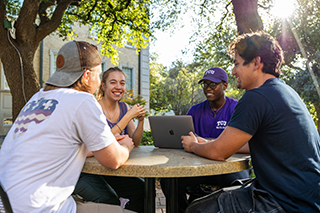 Four students meeting at outdoor table