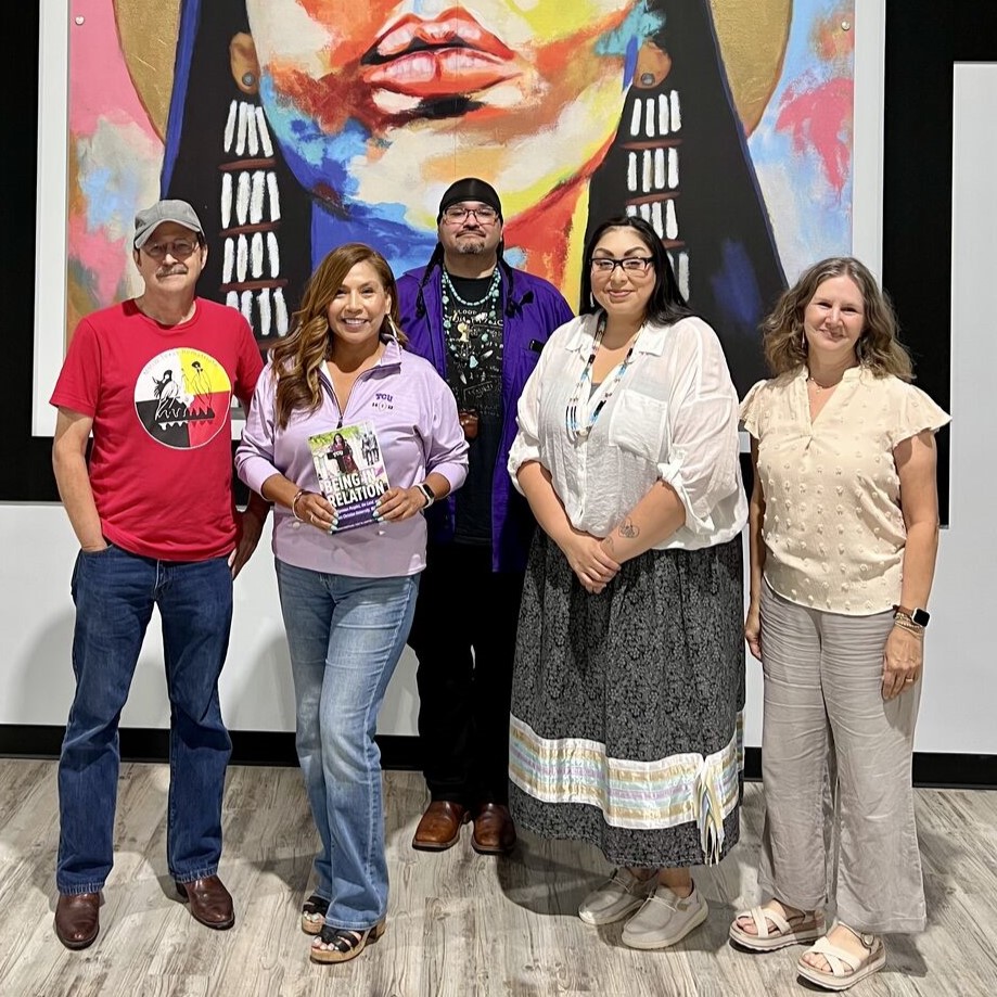 Book Authors and Contributors posing in front of a mural