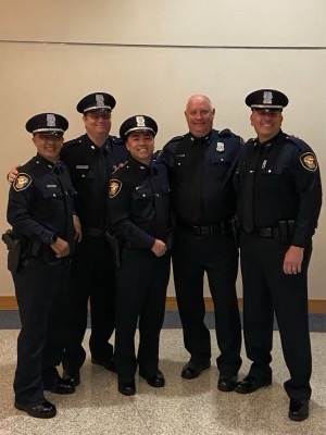 Johnny Nhan, Ph.D., (center) stands with Fort Worth Police Department officers after graduating as a reserve police officer. 