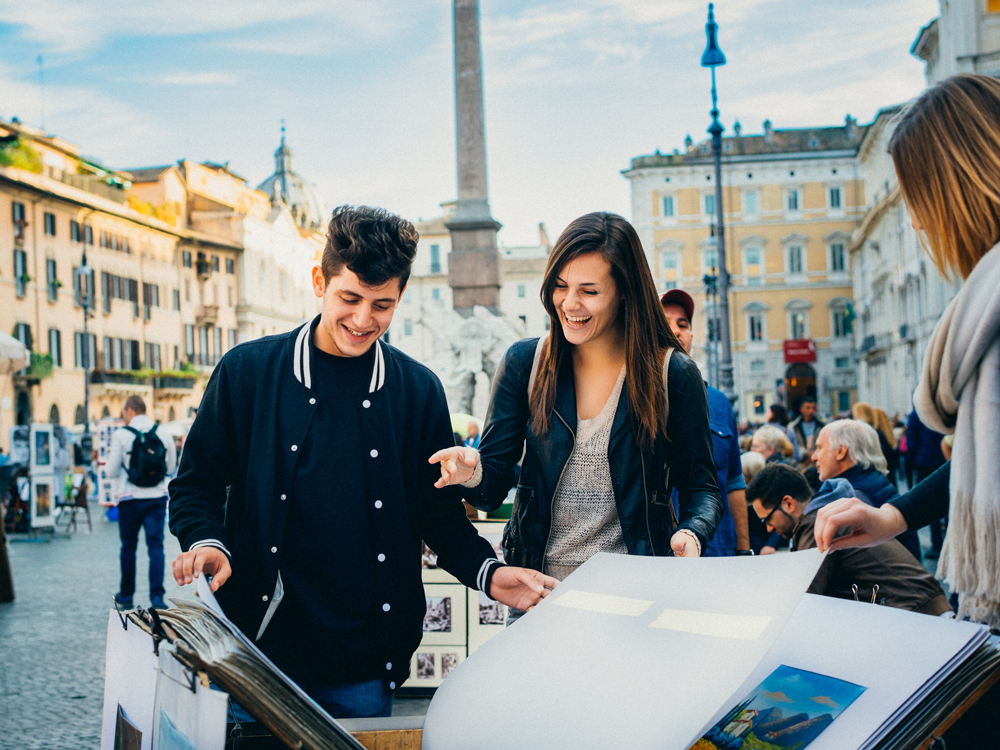 Students flip through a book of artwork in Italy
