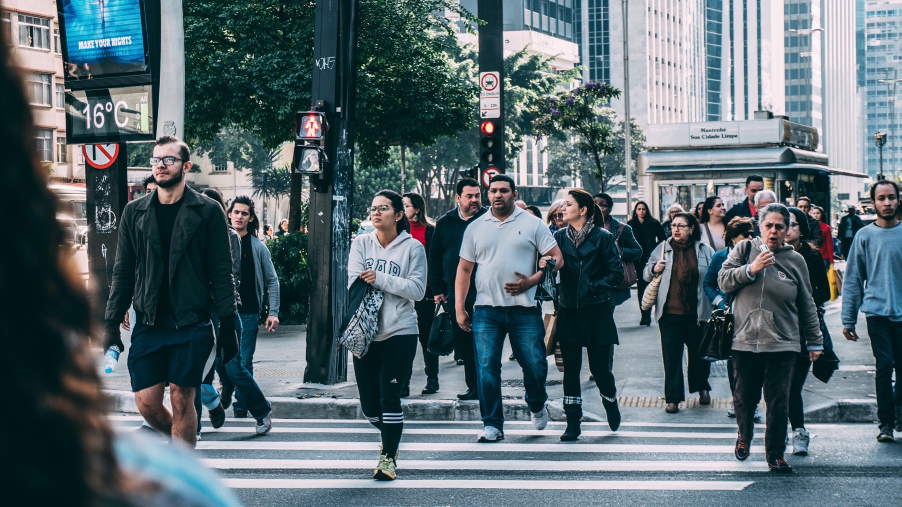People cross a busy street