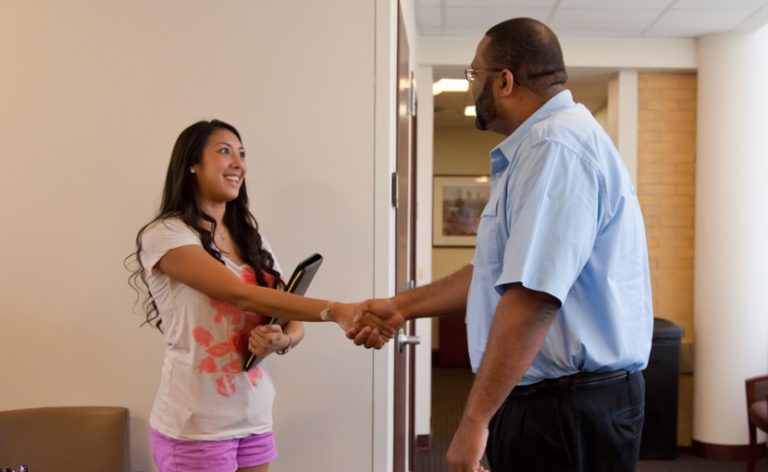 A student shakes hands with her advisor