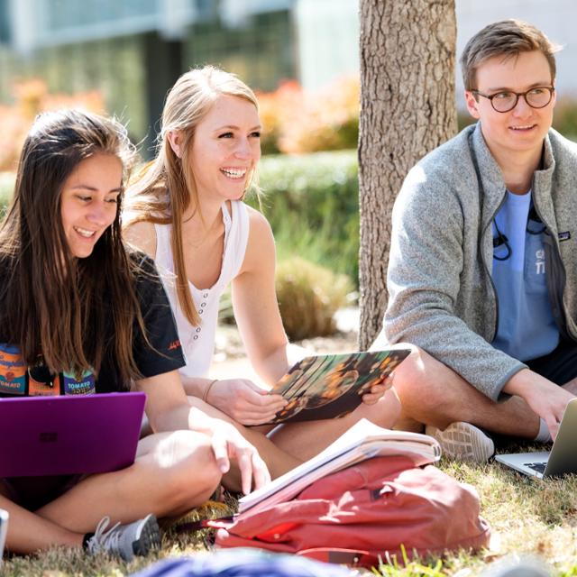 Students sitting in a circle on TCU lawn