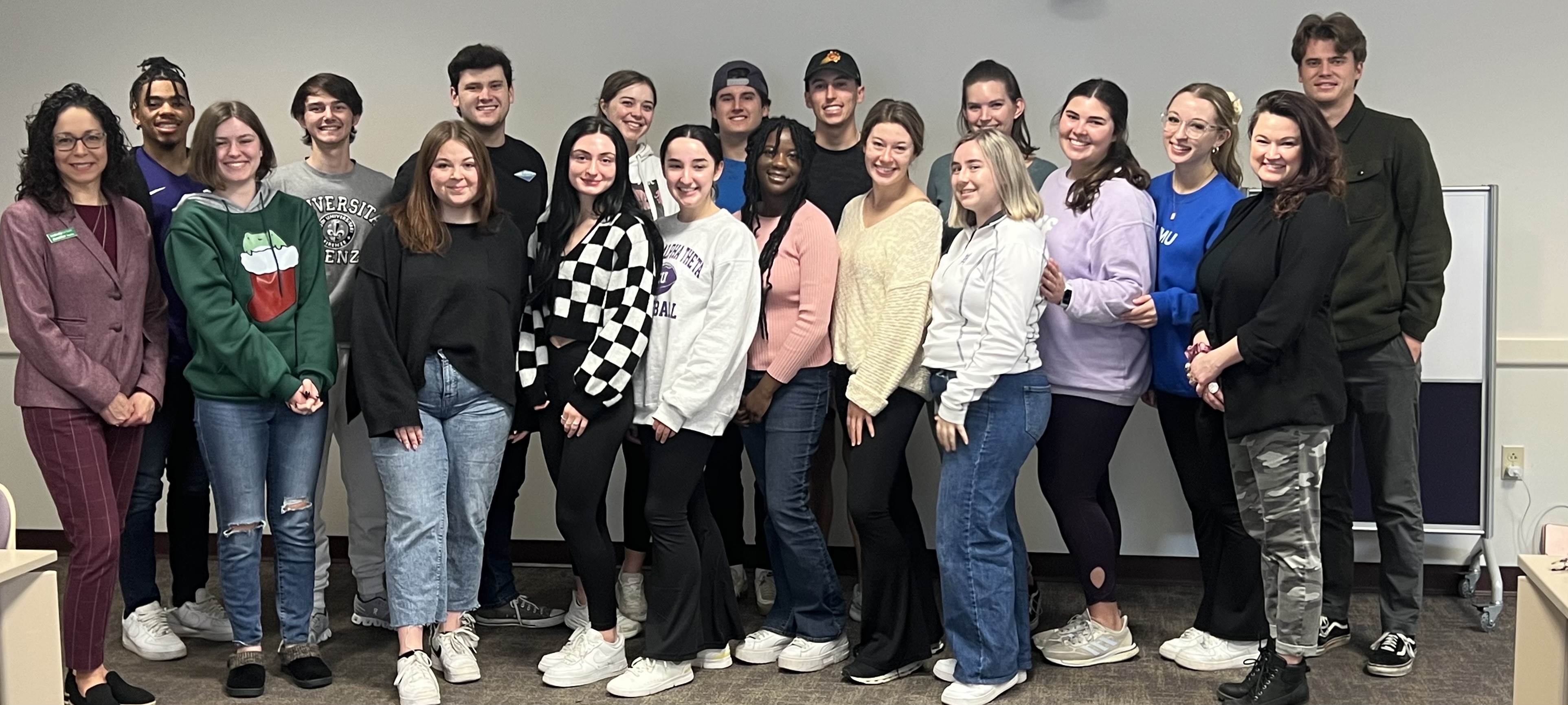 Group of people standing and posing for a picture. 