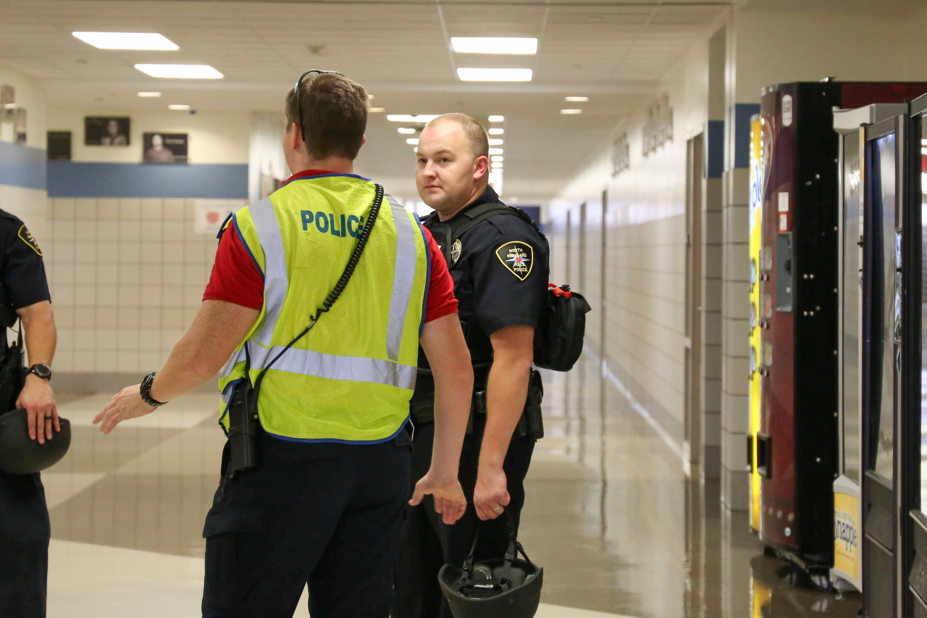 Andrew Bray (center) consults with colleagues after an annual active shooter drill in a local high school. Credit Andrew Bray