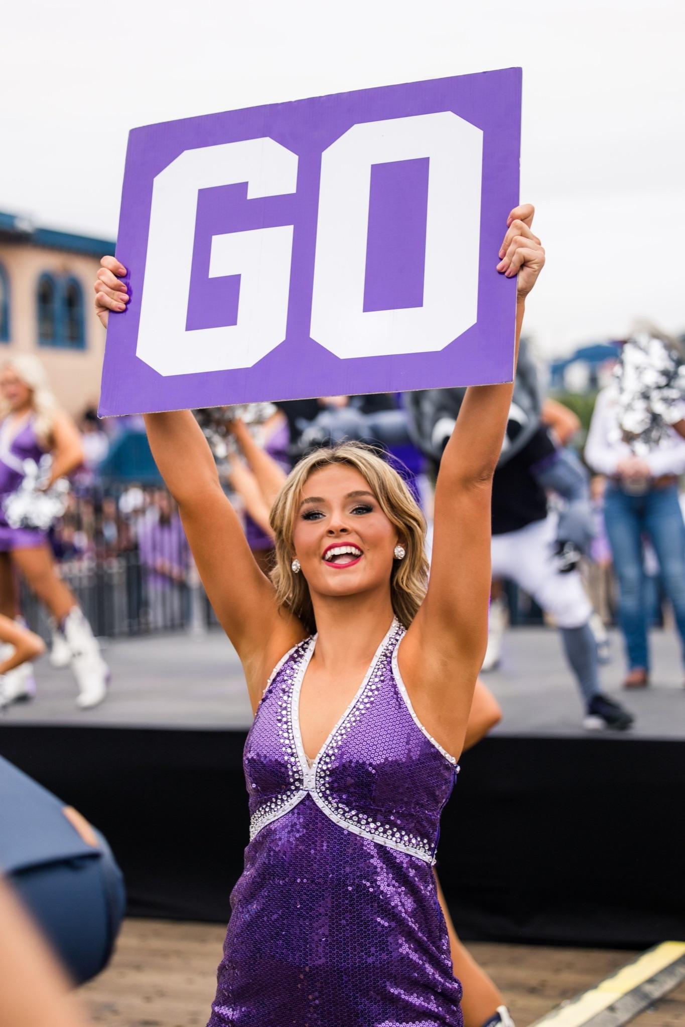 Trinity holding a sign