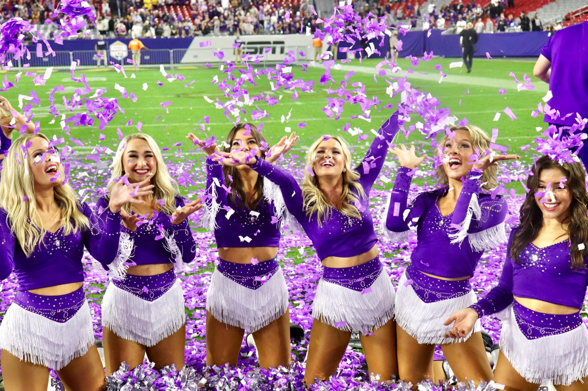 Trinity and TCU Showgirls celebrating on the field. 