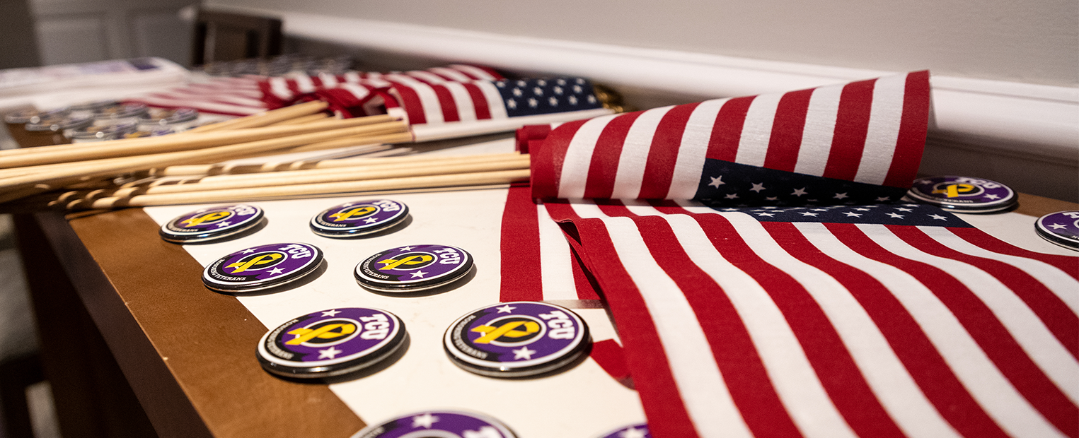 Flags and buttons are laid out on a table during a TCU Veterans Day ceremony. 
