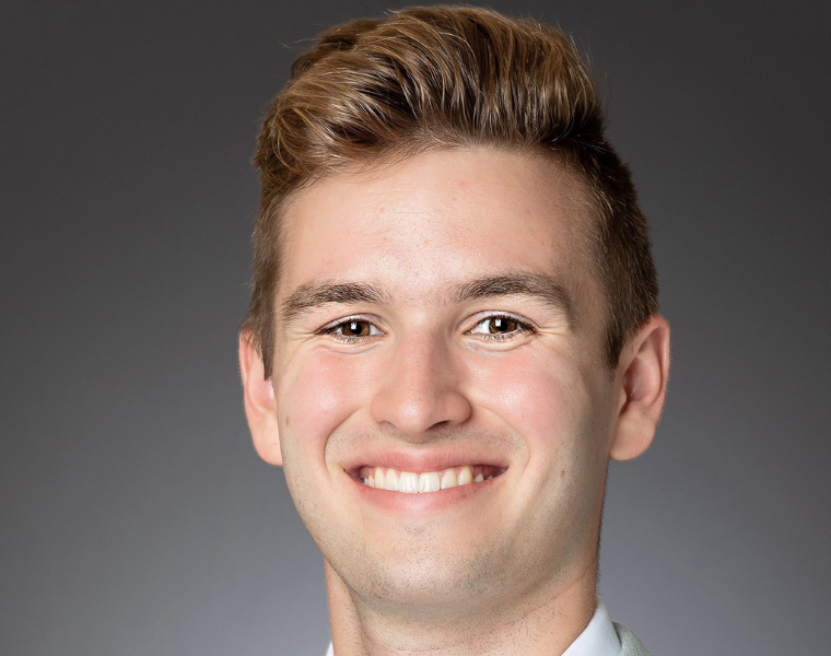A professional headshot of Ethan Gray.