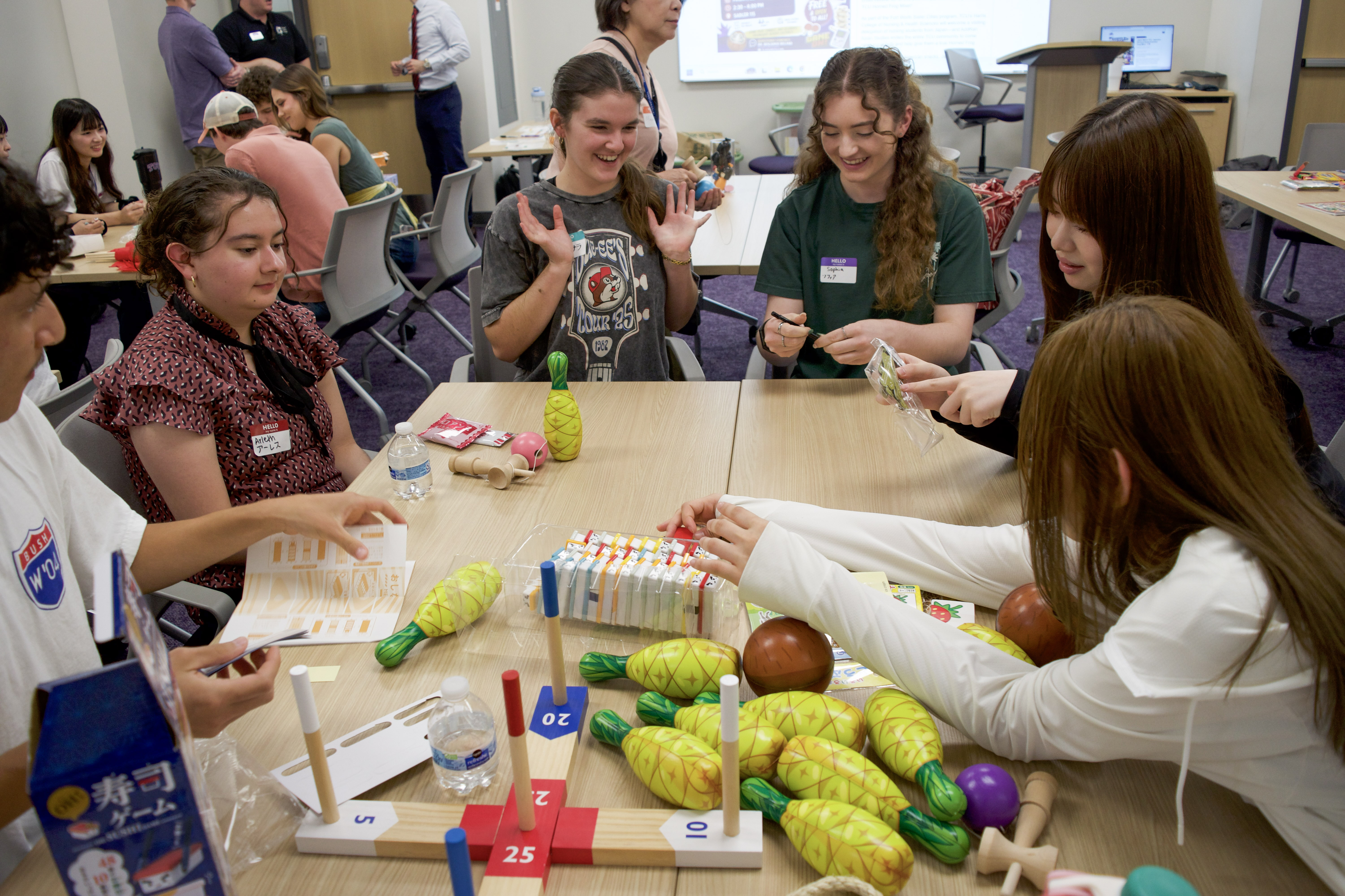 A group of students sitting around a table engaging in a creative activity with various craft supplies.