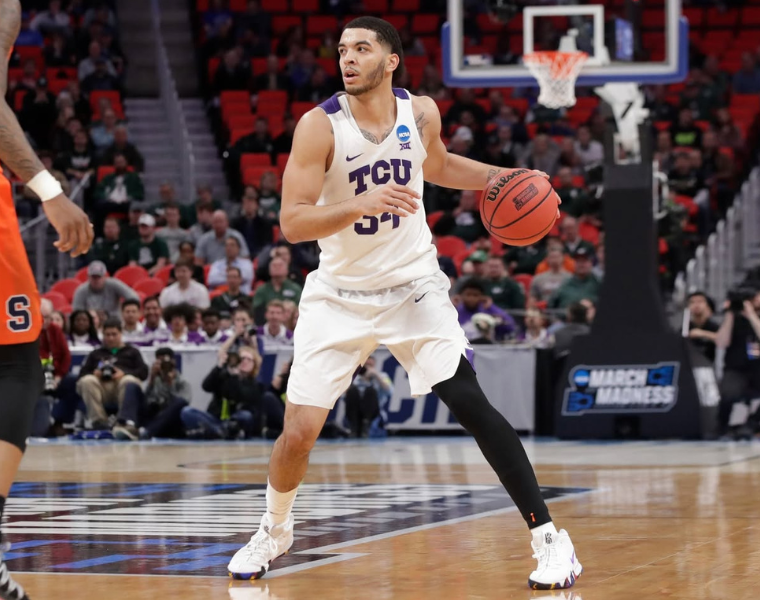 Kenrich Williams dribbling a basketball in a TCU uniform.