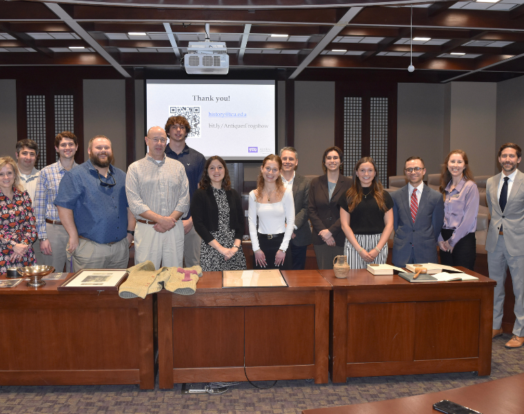 Group of faculty and students at the Antique Frogshow smiling for a picture.