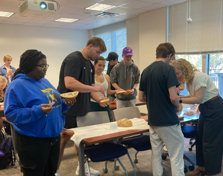 Students in Melissa Reynolds' History of Science course using bread to create molds for casting in wax. Professor Reynolds is showing them how to use the bread.
