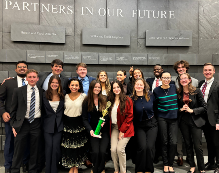 A picture of the TCU Mock Trial group holding the team trophy and smiling.