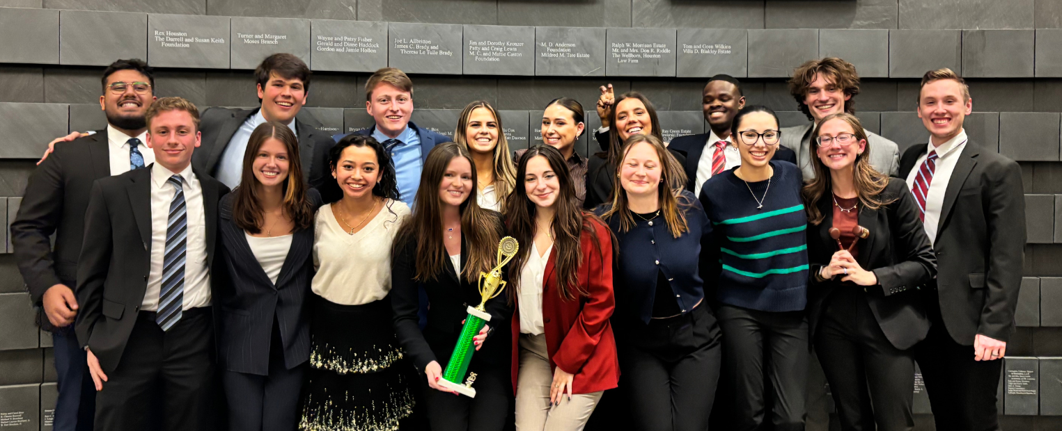 A picture of the TCU Mock Trial group holding the team trophy and smiling.